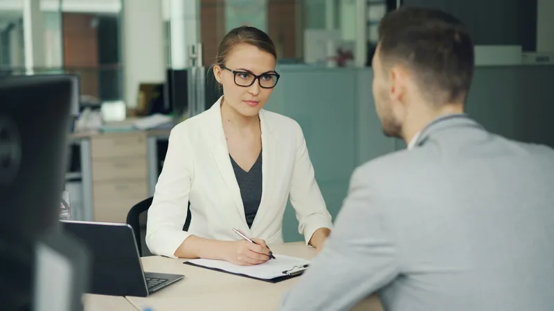 Entretien de recrutement entre une chargée RH et un candidat dans un bureau