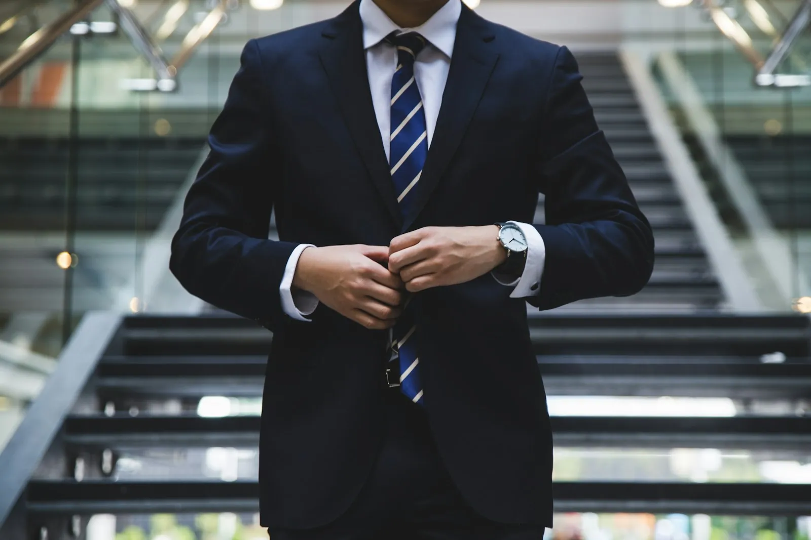 Jeune diplômé en costume ajustant sa veste avant un entretien en banque d'affaires