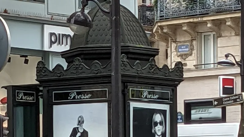 Kiosque à journaux parisien couvert d’affiches publicitaires, boulevard Saint-Michel