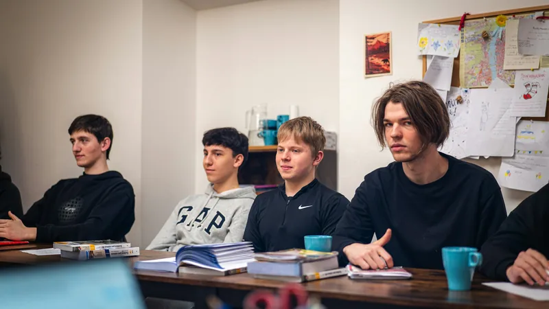 Élèves de terminale attentifs pendant un cours, cahiers et manuels ouverts sur les tables
