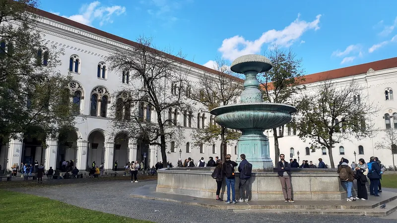 Étudiants réunis autour d’une fontaine devant le bâtiment principal de l’université Louis-et-Maximilien de Munich